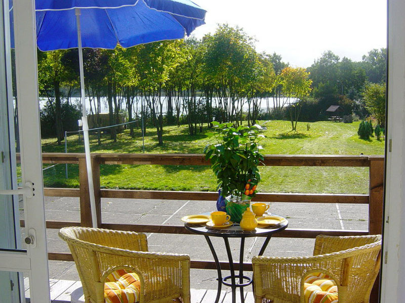 Ferienwohnung für 6 Personen - Blick vom Balkon zum Garten und See
